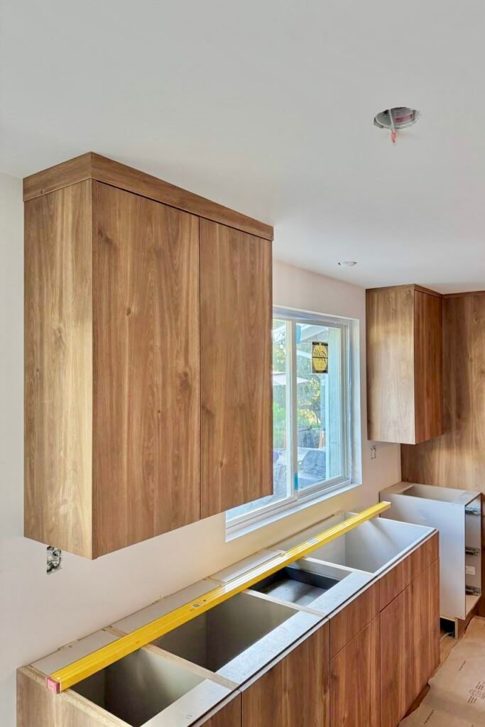 new cabinets before countertop installation for a kitchen remodeling in seattle. Level shows the evenness of the cabinets.
