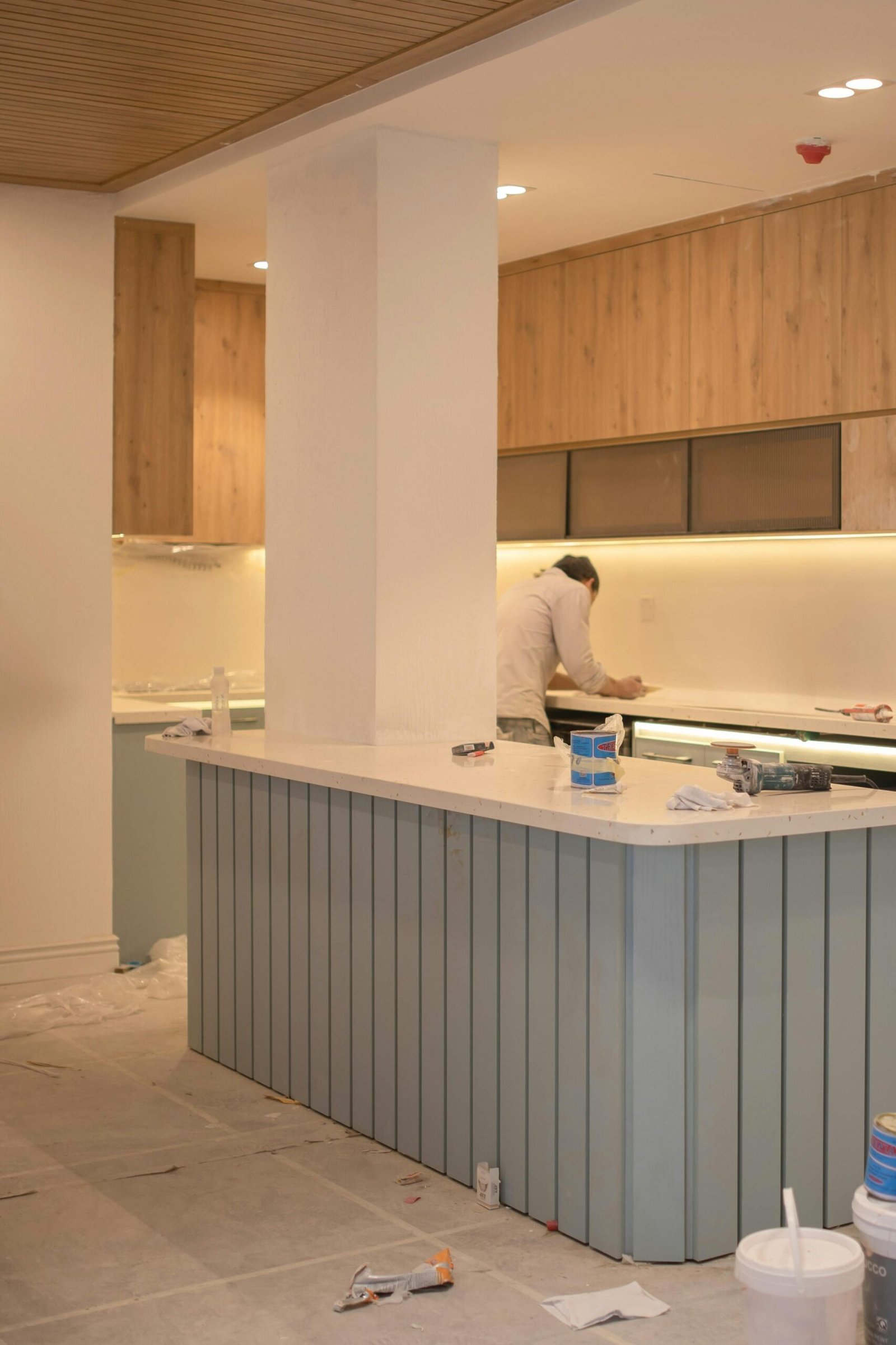Contemporary kitchen undergoing renovation with wooden cabinets and clean design.